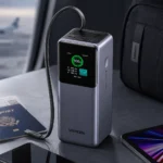 UGREEN 20000mAh 165W Nexode Smart Display Power Bank with Retractable USB-C Cable in Travel Workspace Setup